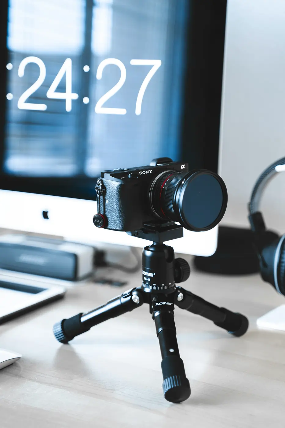 A camera on a tripod in front of a monitor
